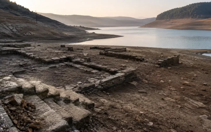 Low reservoir exposing stone foundations and a former road along the shoreline